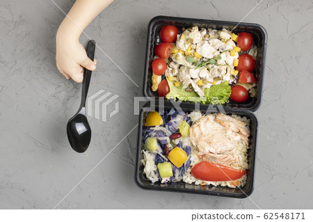 girl holds spoon to eat school lunch into food girl holds spoon to eat school lunch into food 62548171