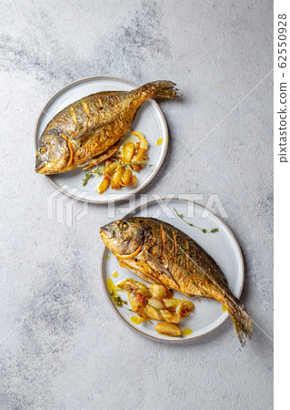 Grilled sea bream or dorada on gray plate. Gray background 62550928
