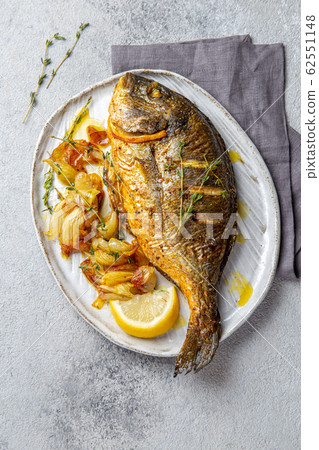 Grilled sea bream or dorada on gray plate. Gray background Grilled sea bream or dorada on gray plate. Gray background 62551148