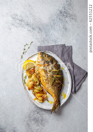 Grilled sea bream or dorada on gray plate. Gray background Grilled sea bream or dorada on gray plate. Gray background 62551212