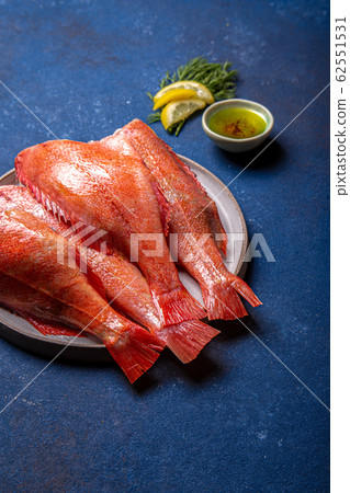 Fresh red sea bass on blue background. Top view, copy space 62551531