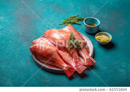 Fresh red sea bass on blue background. Top view, copy space 62551604