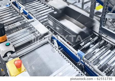 Modern conveyor system with box in motion. Modern conveyor system with box in motion. 62551730