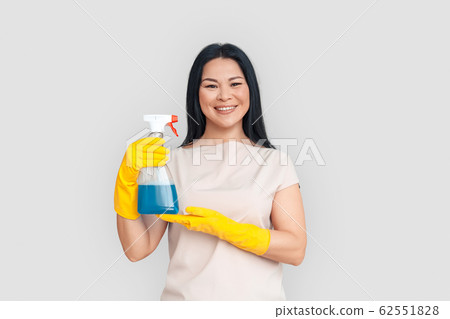 Freestyle. Asian woman in gloves standing isolated on white posing with spray smiling cheerful Freestyle. Asian woman in gloves standing isolated on white posing with spray smiling cheerful 62551828