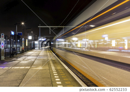 A train passes by at the train station in Sassenheim 62552233