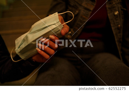 medical disposable mask in the hands of young 62552275