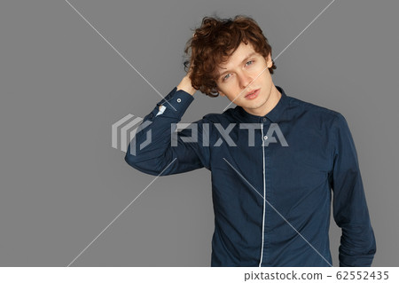 Freestyle. Teenager boy standing isolated on grey scaratching head thoughtful Freestyle. Teenager boy standing isolated on grey scaratching head thoughtful 62552435