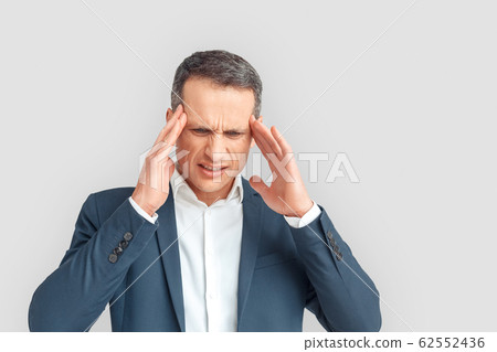 Freestyle. Mature businessman standing isolated on white having headache looking down unhappy Freestyle. Mature businessman standing isolated on white having headache looking down unhappy 62552436