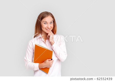 Freestyle. Young businesswoman standing isolated on white with notebook posing smiling joyful Freestyle. Young businesswoman standing isolated on white with notebook posing smiling joyful 62552439