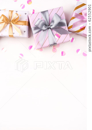 Gift boxes with bows and confetti on a white background. Gift boxes with bows and confetti on a white background. 62552901