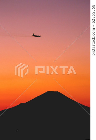 海上自衛隊的P-3C Orion巡邏機在傍晚的天空中飛行，富士山的輪廓漂浮在美麗的茜空中 62555359