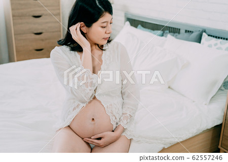 Gorgeous girl on bed hold bare belly expect baby Gorgeous girl on bed hold bare belly expect baby 62557246
