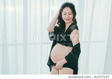 future mom in sexy bra flicks hair with smile. future mom in sexy bra flicks hair with smile. 62557247