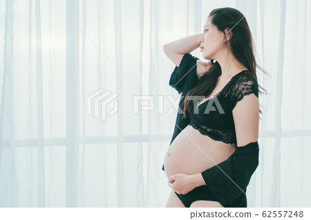 pensive motherhood looking out window in room pensive motherhood looking out window in room 62557248