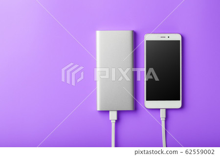 Power Bank charges your smartphone on a purple 62559002