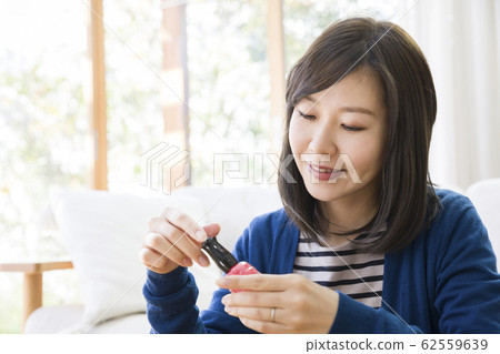 一位年輕的女士畫指甲油 一位年輕的女士畫指甲油 62559639