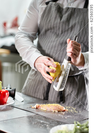 Chief chops and marinates chicken. Professional chef in a kitchen of restaurant cooking. 62560395