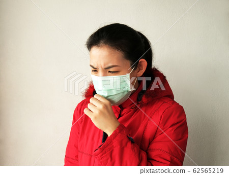 Asian woman wearing face mask and coughing on 62565219
