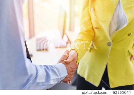 Business people shaking hands standing with 62565644