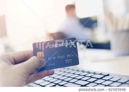 Business man holding credit card payment in a Business man holding credit card payment in a 62565646