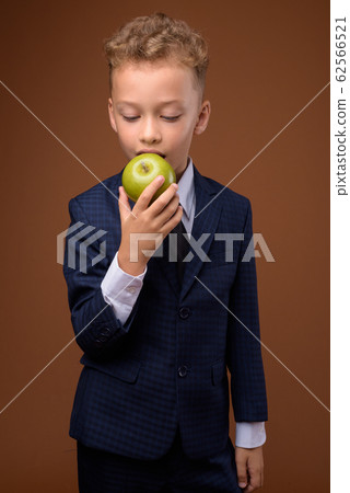 Young boy as businessman against brown background Young boy as businessman against brown background 62566521