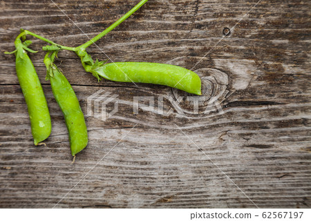 Green peas in a wooden bowl. Green peas in a wooden bowl. 62567197