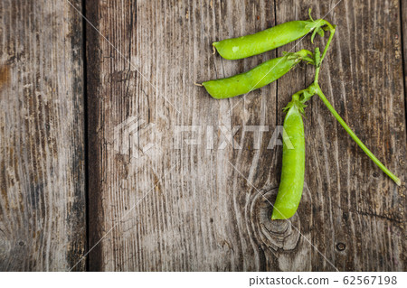 Green peas in a wooden bowl. 62567198