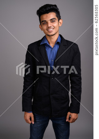 Young Indian businessman against gray background Young Indian businessman against gray background 62568305