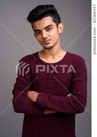 Young Indian man against gray background Young Indian man against gray background 62568337