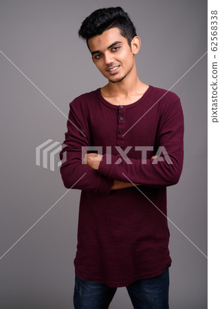 Young Indian man against gray background 62568338