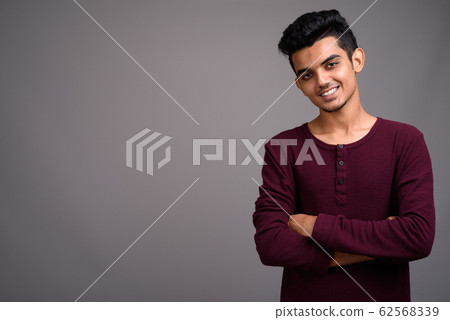 Young Indian man against gray background Young Indian man against gray background 62568339