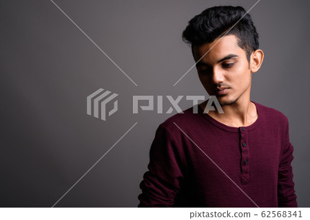 Young Indian man against gray background Young Indian man against gray background 62568341