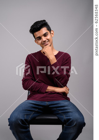 Young Indian man against gray background 62568348