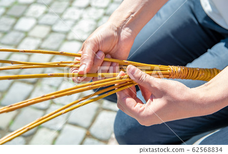 a woman weaves his Easter whip from a rod a woman weaves his Easter whip from a rod 62568834