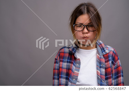 Young beautiful Kazakh woman against gray background Young beautiful Kazakh woman against gray background 62568847
