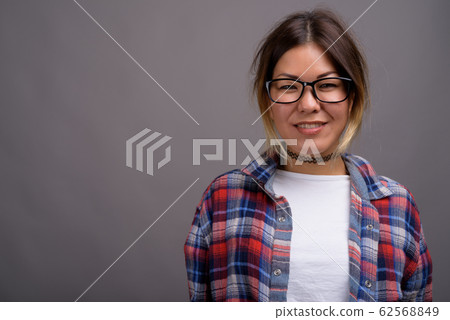 Young beautiful Kazakh woman against gray background Young beautiful Kazakh woman against gray background 62568849