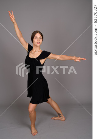 Young beautiful woman against gray background Young beautiful woman against gray background 62570327