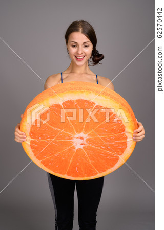 Young beautiful woman ready for gym against gray background 62570442