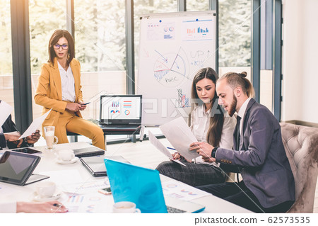Group of happy diverse male and female business people in formal gathered around laptop computer in bright office Group of happy diverse male and female business people in formal gathered around laptop computer in bright office 62573535