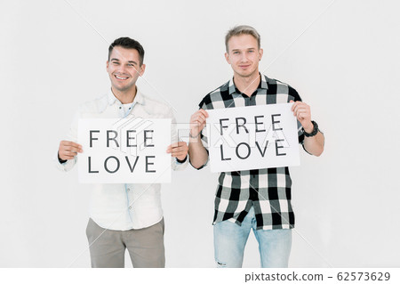 Two handsome Caucasian men LGBT activists fighting against gays discrimination, free equal love, holding posters with slogans, standing on white background 62573629