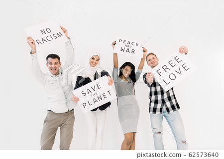 Young four multiethnical activists, volunteers, ecologists with banners shouting about racism, saving earth, no war, equal rights, standing isolated on white background Young four multiethnical activists, volunteers, ecologists with banners shouting about racism, saving earth, no war, equal rights, standing isolated on white background 62573640