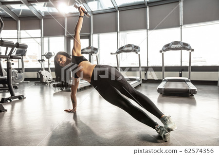 The female athlete training hard in the gym. Fitness and healthy life concept. 62574356