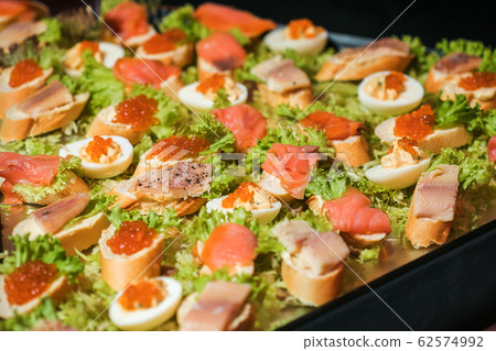 Sandwiches with caviar. Red caviar. Food on the holiday table. Snacks on a plate. Sandwiches with caviar. Red caviar. Food on the holiday table. Snacks on a plate. 62574992