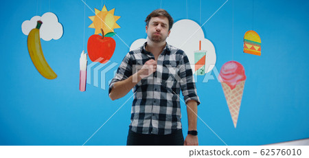 Man fascinated by unhealthy fast food Man fascinated by unhealthy fast food 62576010