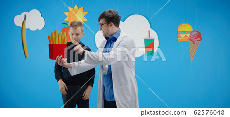 Doctor explaining to boy about healthy and unhealthy food Doctor explaining to boy about healthy and unhealthy food 62576048