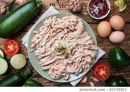 Raw minced chicken on a plate with spices on a Raw minced chicken on a plate with spices on a 62576921