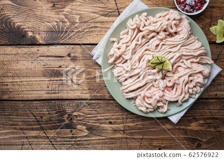 Raw minced chicken on a plate with spices and Raw minced chicken on a plate with spices and 62576922