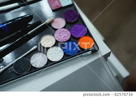 Palette of shadows for makeup on a blurred background, closeup Palette of shadows for makeup on a blurred background, closeup 62578716