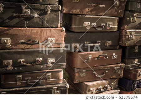 Vintage suitcases stacked in a heap. Vintage suitcases stacked in a heap. 62579574