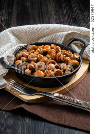 Cast iron skillet with fried champignon 62579947